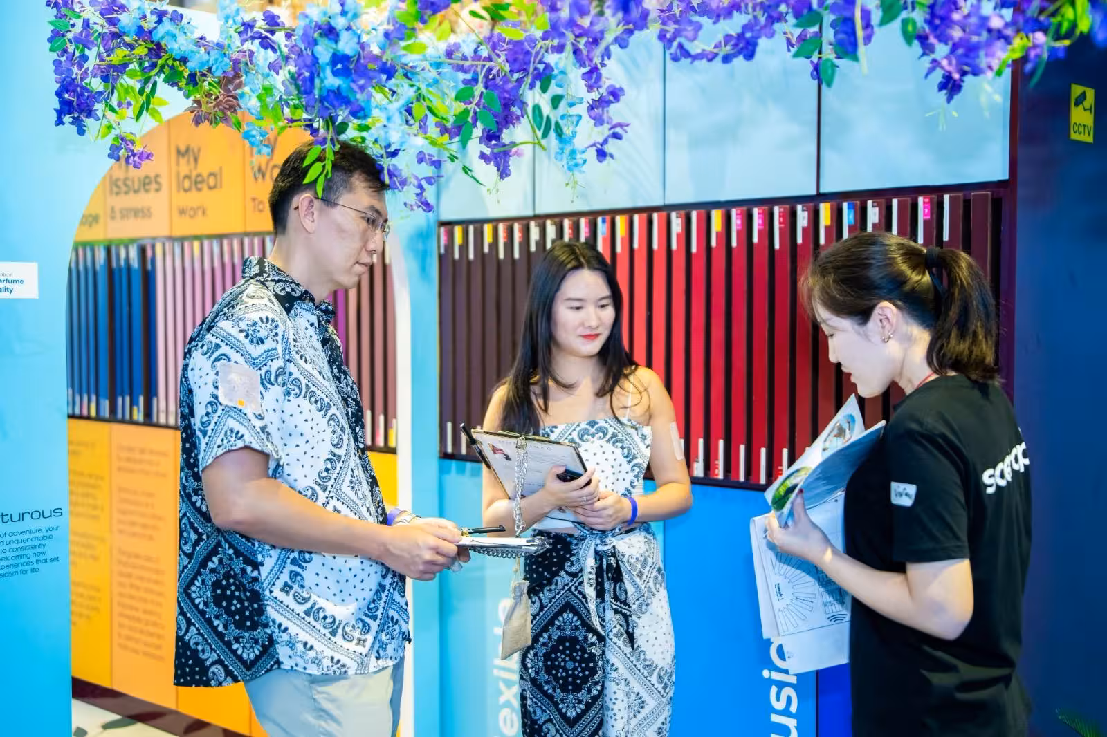 Group interacting with instructor during DIY perfume workshop at Sentosa, Singapore, surrounded by colorful decor.