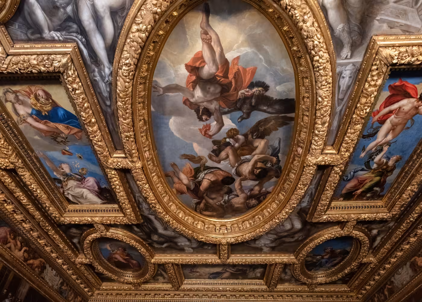 Ornate gilded ceiling art in the Doge's Palace, featuring mythological scenes, part of the Venice history tour.