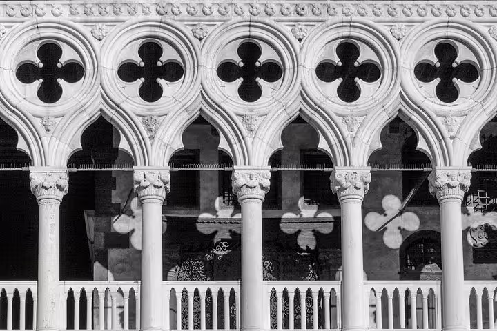 Close-up of the ornate Gothic arches of the Doge's Palace in Venice, showcasing intricate stonework and design.