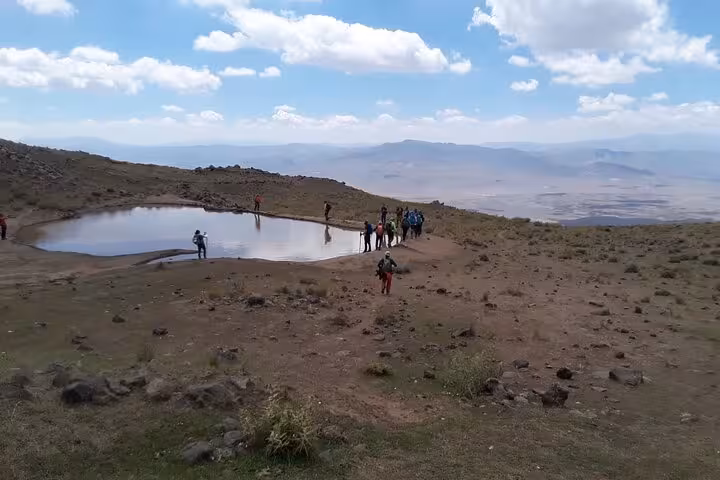 Hikers by a crater lake viewpoint near Dogubeyazit on an all-inclusive private guided day tour in Turkey