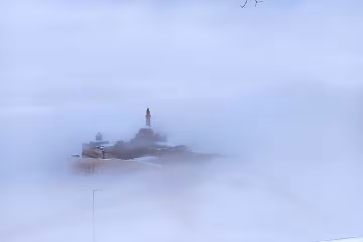 Foggy winter view of Dogubeyazit with mosque minaret emerging, Turkey private guided city tour