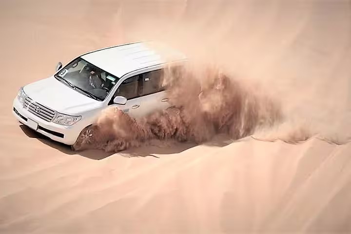 SUV navigating through the golden dunes on Doha's thrilling desert safari adventure tour.