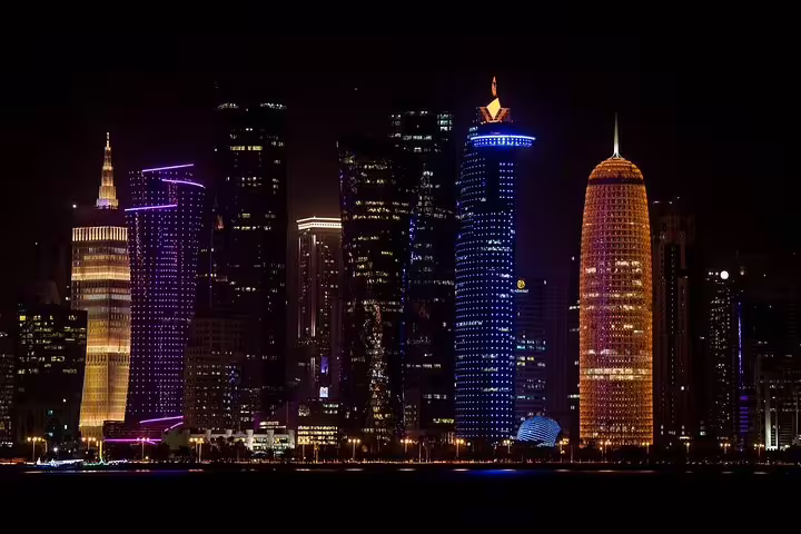 Marvel at Doha's stunning skyline illuminated at night, a breathtaking view on the private city tour with local meal option.