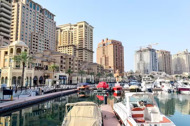 The Pearl-Qatar marina with luxury yachts, iconic high-rise buildings, and vibrant waterfront in Doha.