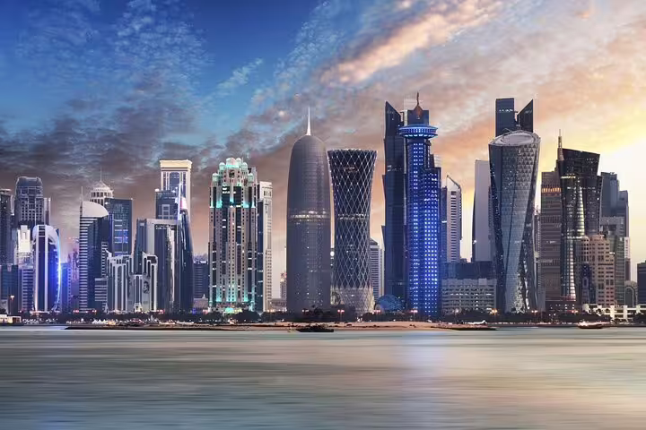 Stunning Doha skyline at sunset showcasing modern architecture along the Corniche, perfect for city tours.