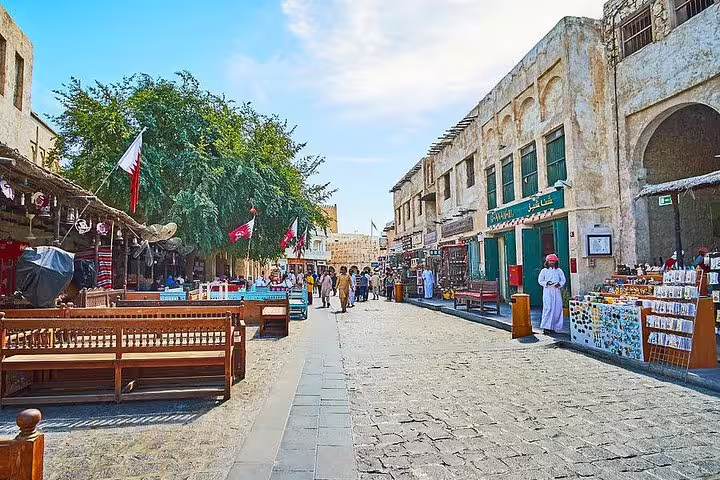 Vibrant scene at Souq Waqif in Doha with bustling market stalls and traditional architecture, ideal for cultural tours.