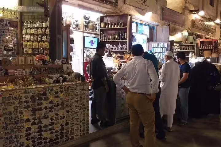 Visitors exploring a bustling souvenir shop in Souq Waqif, a must-see on any customizable Doha city tour.