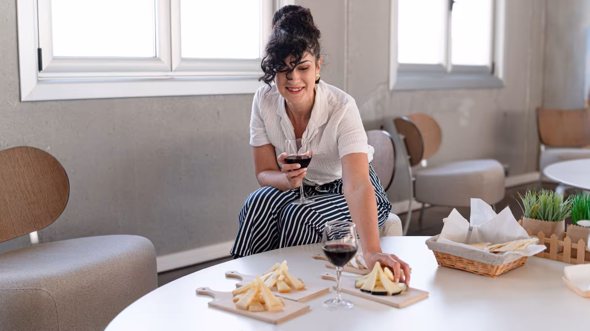 Woman enjoying cheese and wine tasting at Dolianova cheese factory workshop, showcasing local Sardinian flavors.