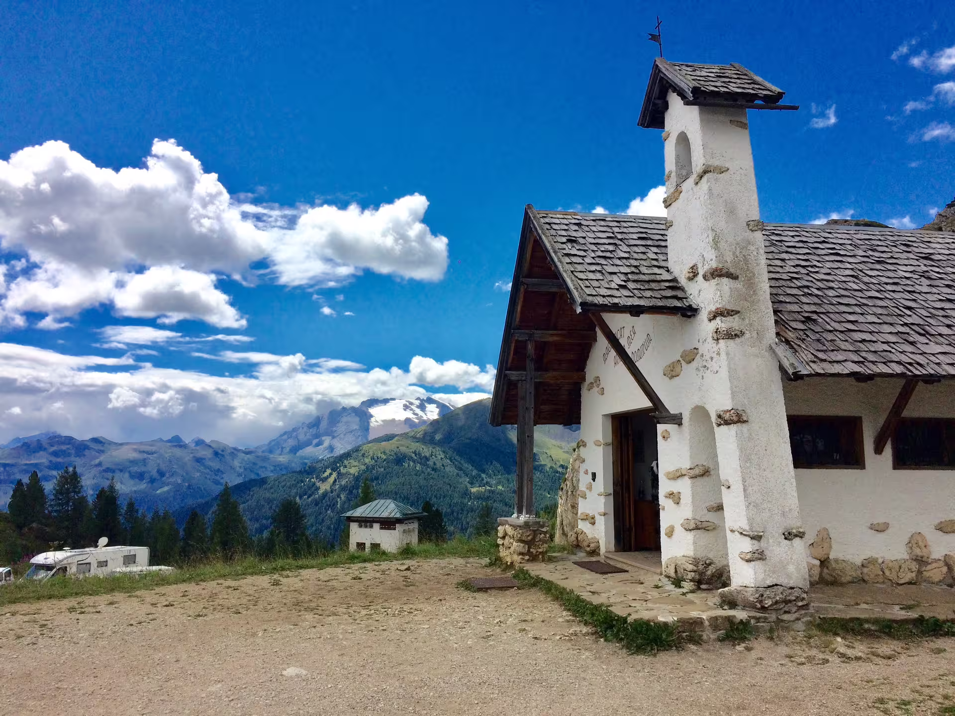Charming chapel with stone roof amidst the scenic Dolomites landscape on a private day trip from Venice.