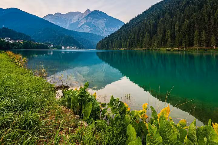 Crystal clear lake surrounded by verdant forests and mountainous landscape in the Dolomites, Italy, near Venice tour.