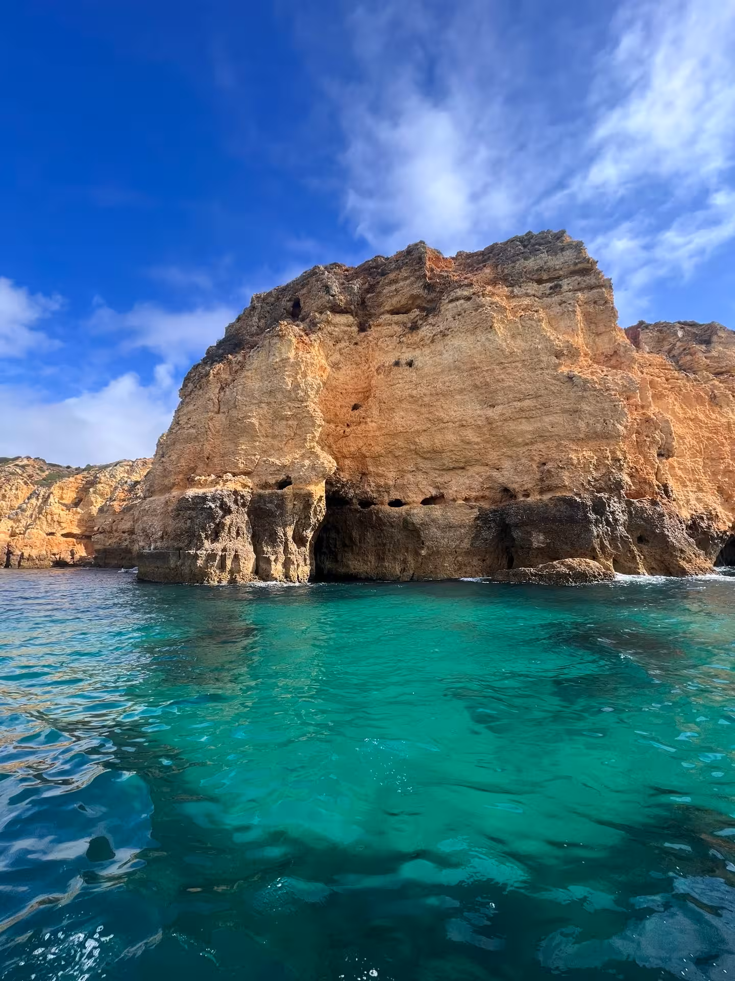Golden Ponta da Piedade cliffs rise above clear turquoise Algarve water on a scenic Lagos boat and dolphin trip