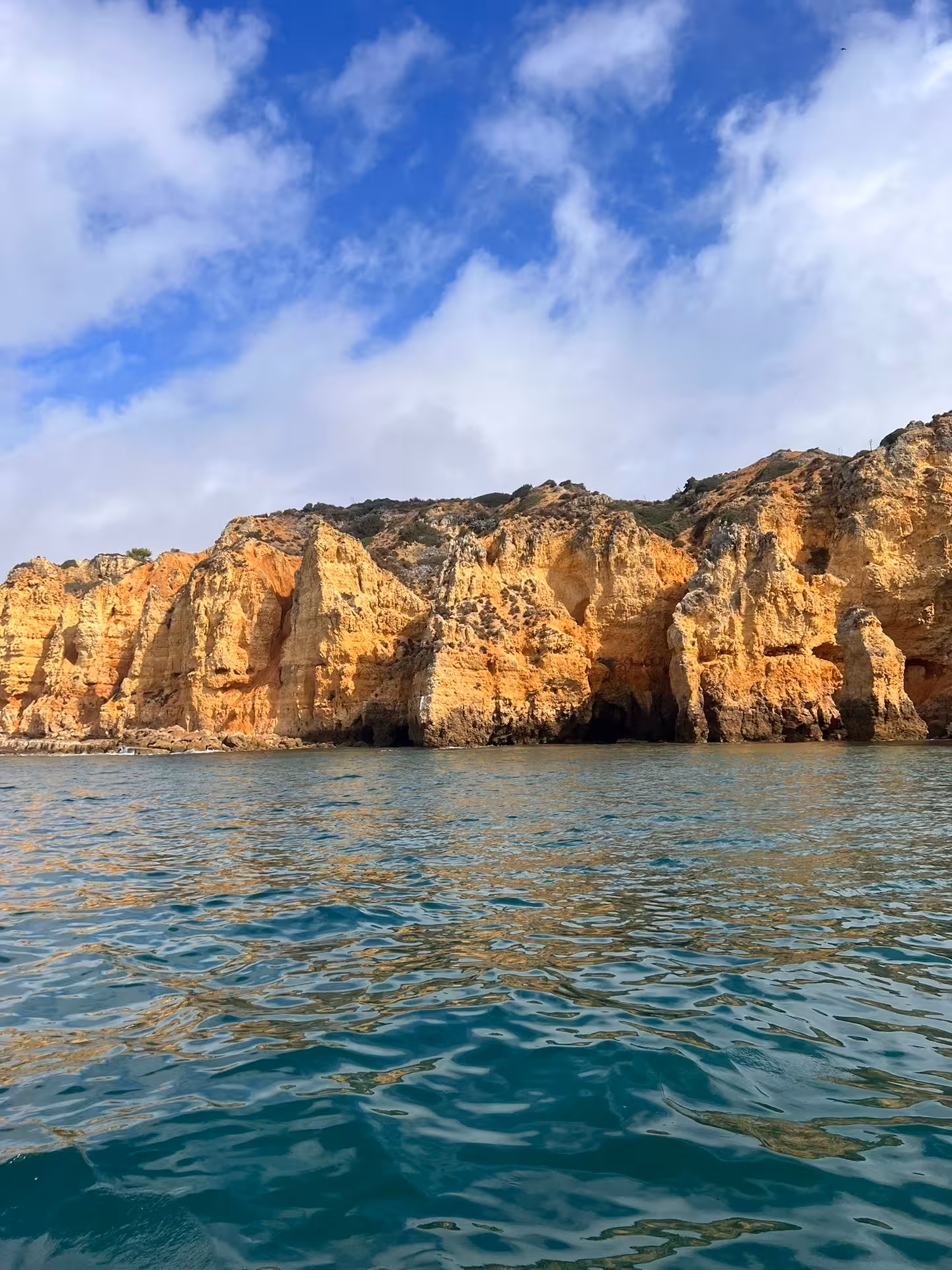 Rugged golden cliffs of Ponta da Piedade border calm blue Atlantic waters on a Lagos Algarve coastal boat tour