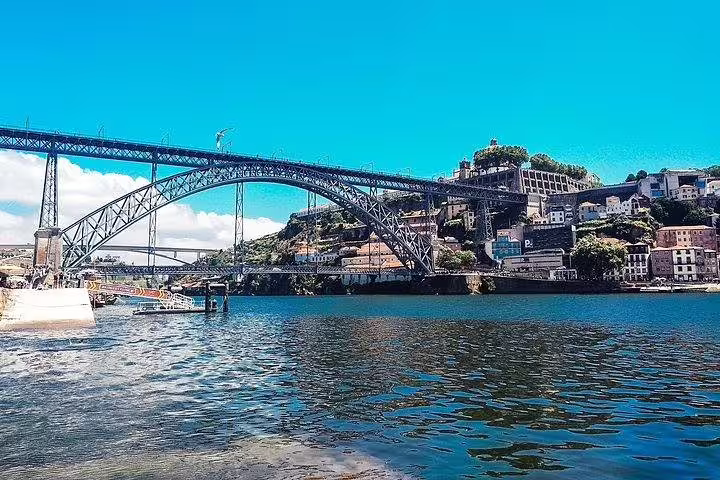 Iconic Dom Luís I Bridge spanning the Douro River in Porto, showcasing architectural marvel on a Lisbon to Porto tour.