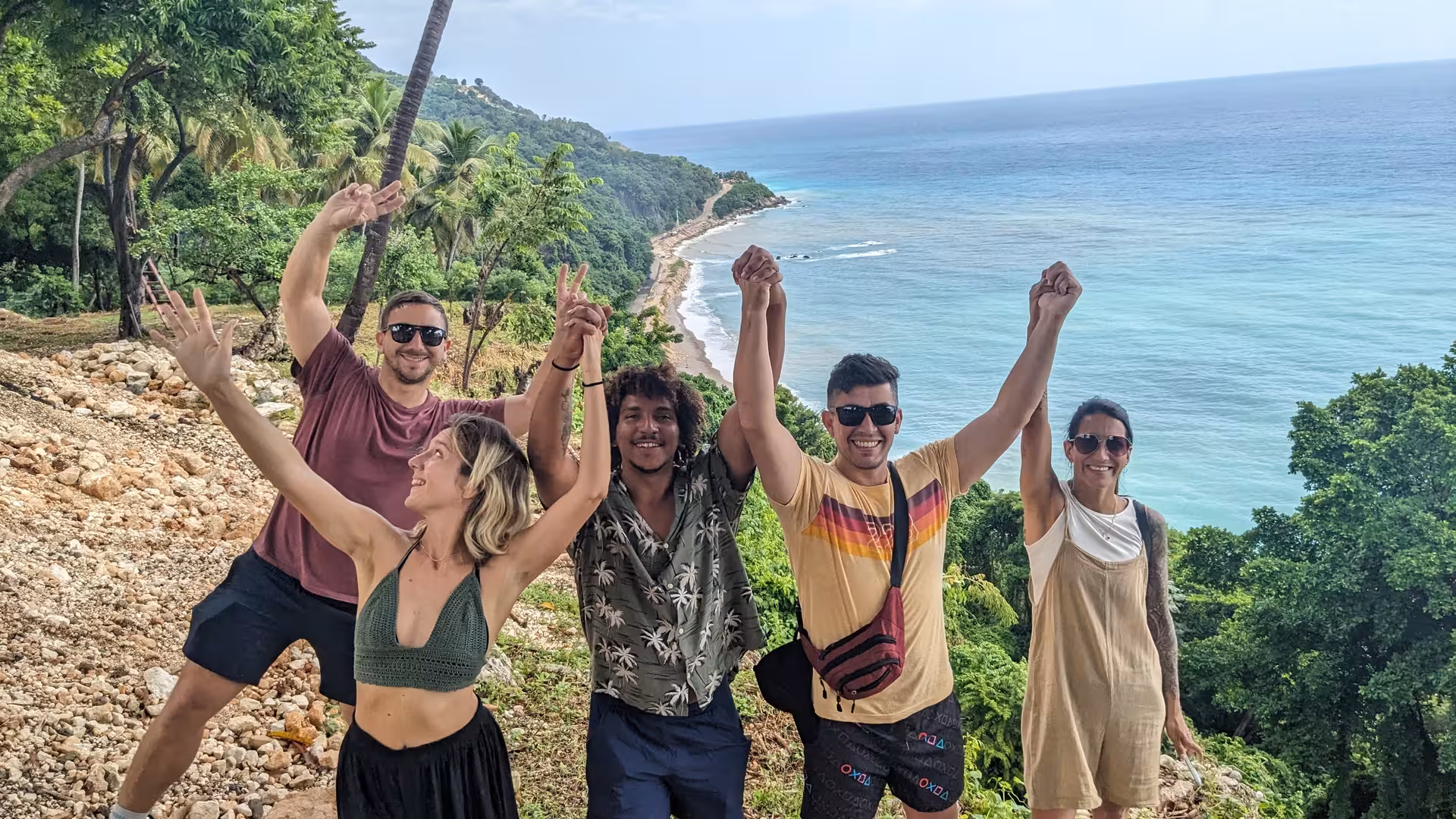 Travelers celebrating at a Dominican Republic coastal lookout during a 7-day self-discovery small-group adventure