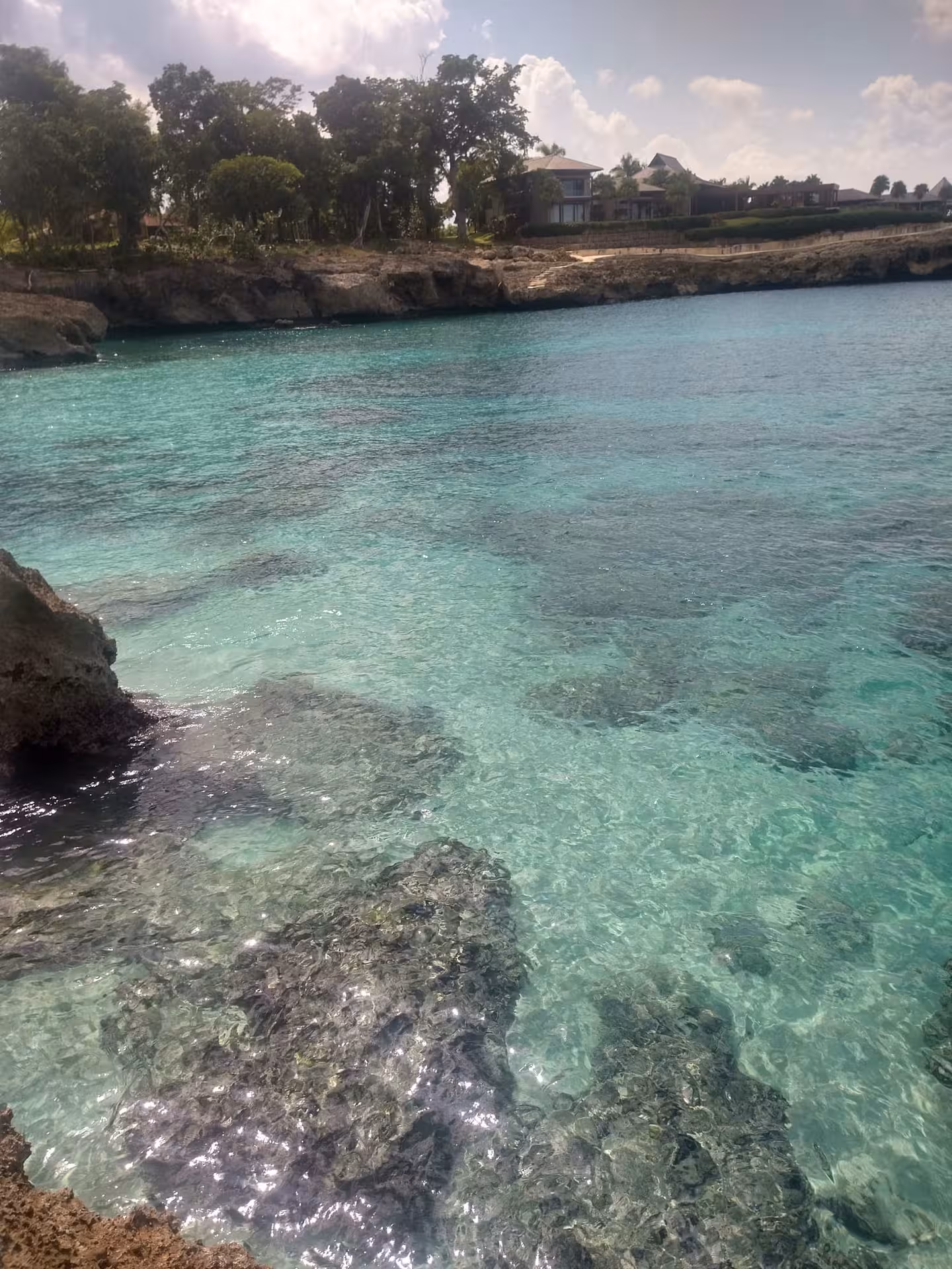 Crystal-clear turquoise cove and rocky shoreline in the Dominican Republic, peaceful ocean stop on a 7-day wellness journey