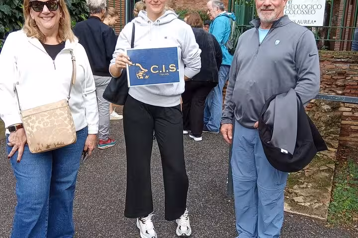 Visitors posing with a C.I.S. Tours sign at the Domus Aurea, eager to start their virtual reality tour in Rome.