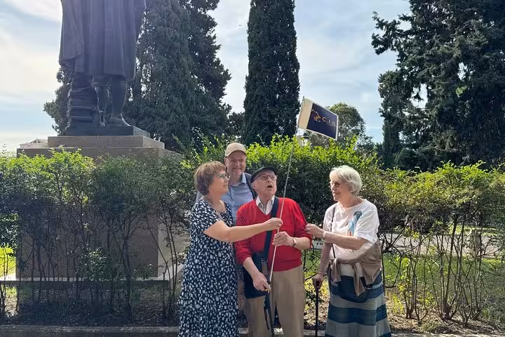Visitors with a C.I.S. sign, standing near a statue, preparing for the Domus Aurea VR experience in Rome.