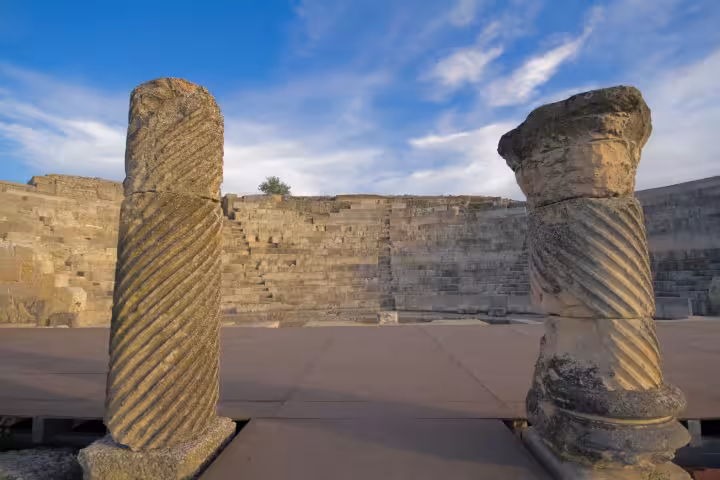 Twisted stone columns framing an ancient amphitheater, heritage site visit on the Don Quixote Tour Spain
