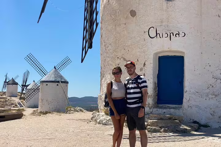 Visitors posing by the iconic windmills of Consuegra during the Don Quixote Windmills tour in La Mancha.