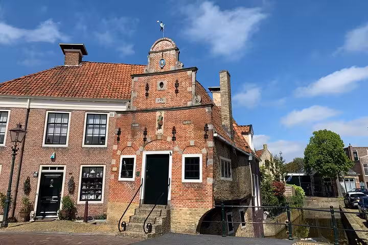 Traditional brick gabled building by canal in Dordrecht, highlight of Best of Dutch Legacy private tour