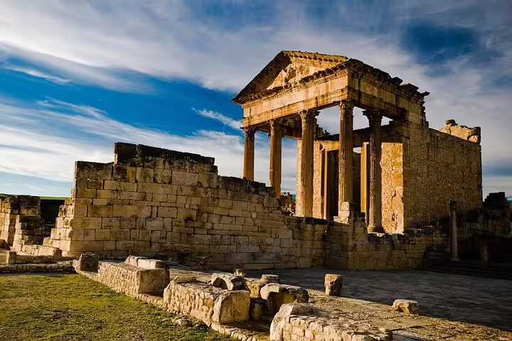Visit the majestic Roman ruins of Dougga under a vibrant sky on the 8 Days Tunisia Essential Discovery Tour.