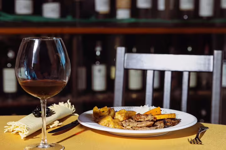 Savor exquisite Douro cuisine with a glass of red wine, perfect for a gourmet dining experience on the 4x4 tour.