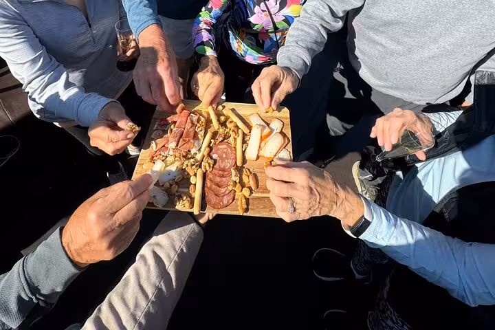Guests share a charcuterie board with local cheeses on a private Douro luxury boat wine tour