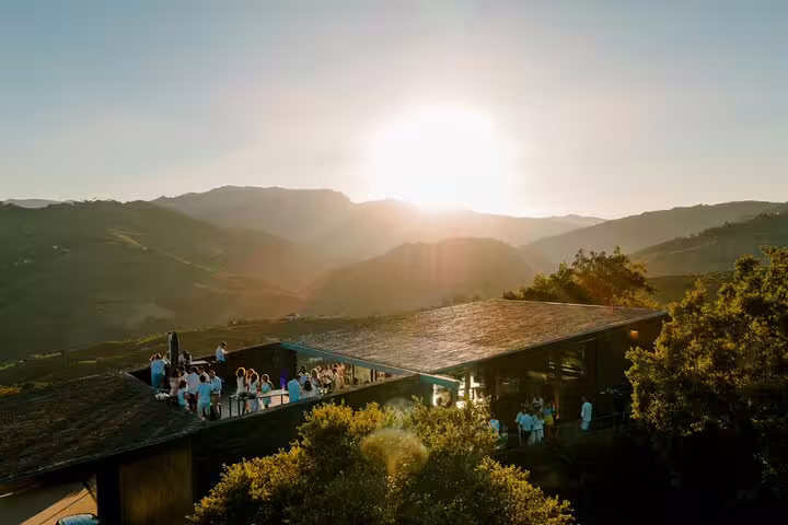 Aerial view of a scenic Douro winery event with a stunning sunset over rolling hills, perfect for a luxury cruise experience.