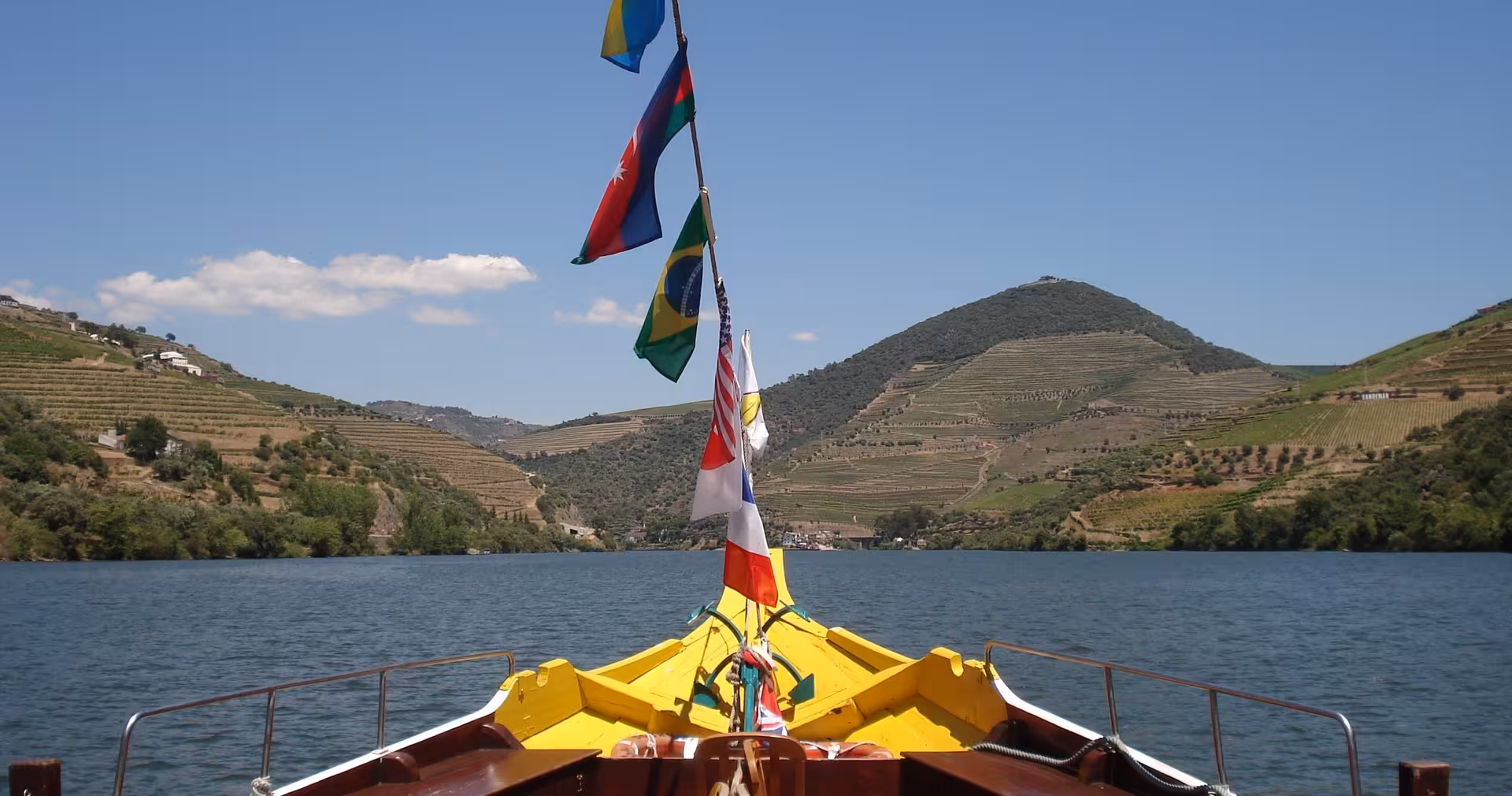 Traditional boat cruise on the Douro River with terraced vineyards, highlight of 7-day Lisbon to Porto tour