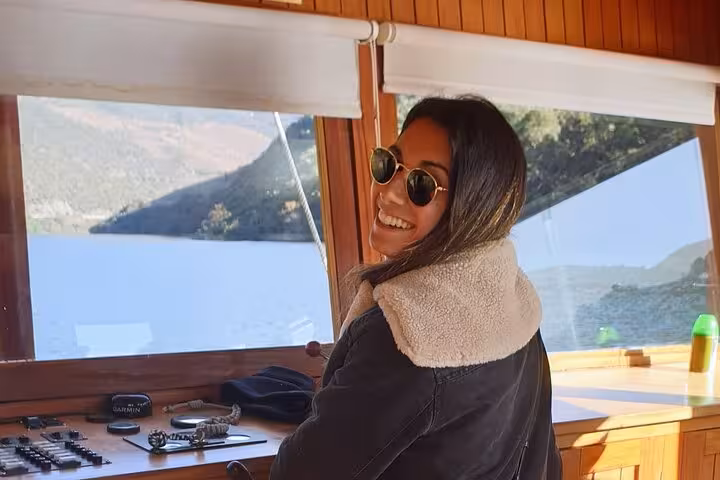 Guest smiling on Douro River boat tour, expert guide cruise with scenic valley views, lunch and wine tastings