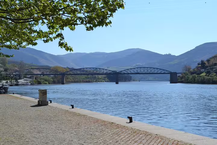 Picturesque bridge over the Douro River with mountains, ideal for a Douro Valley river cruise experience.