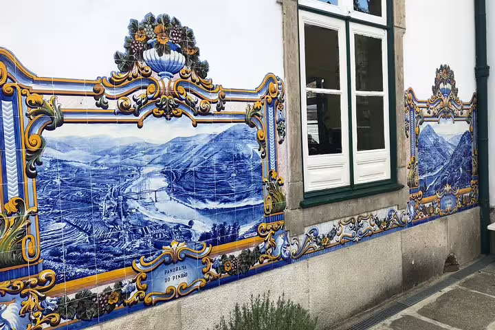 Traditional azulejo tiles depicting Douro River landscape on a building facade.