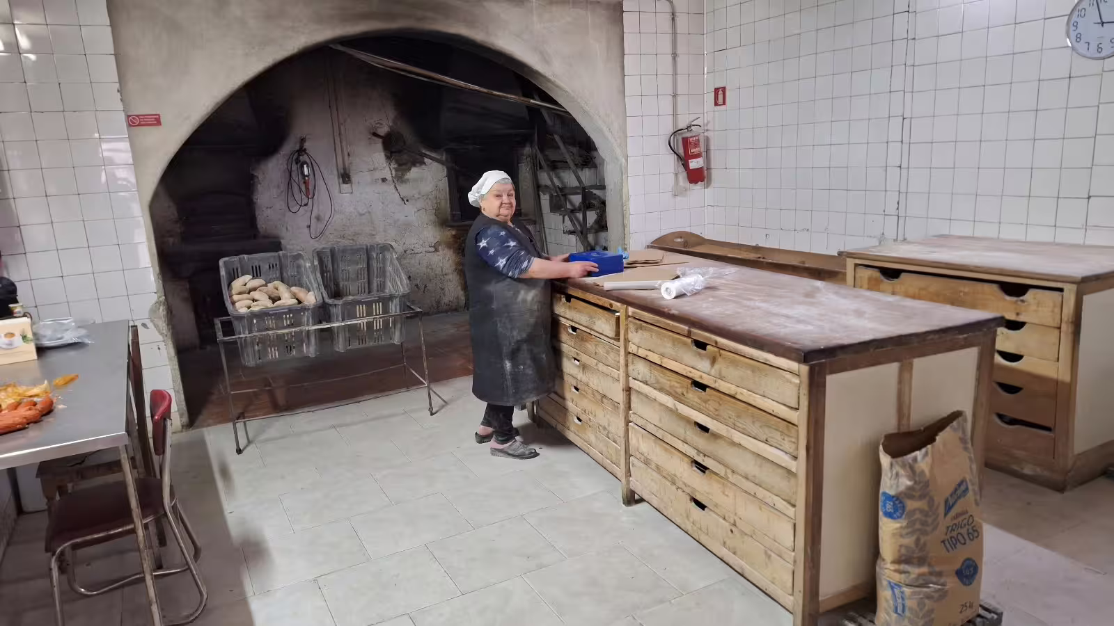 A traditional bakery in the Douro Valley with a baker preparing bread, showcasing authentic culinary experiences on the private tour.