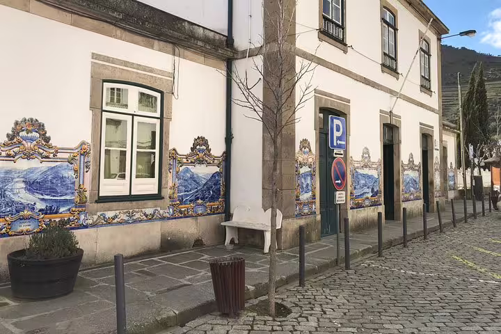 Charming street in Douro Valley with traditional Portuguese azulejos tiles on buildings, highlighting local culture and art.