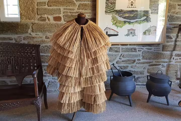 Traditional straw costume displayed in Douro Valley vineyard, showcasing local heritage and culture.