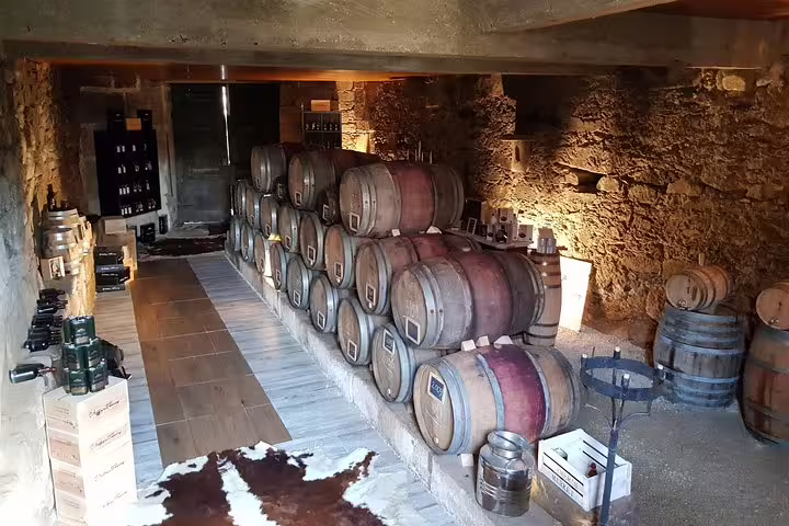 Cozy wine cellar with stacked barrels at a Douro Valley vineyard, showcasing authentic Portuguese winemaking ambiance.
