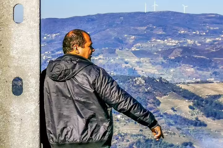 A man in a black jacket overlooks the scenic Douro Valley vineyards and hills during a private tour from Lisbon.