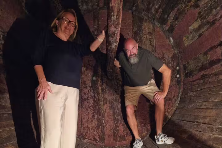 Tourists explore inside a large wine barrel at a Douro Valley winery on a luxury tour.