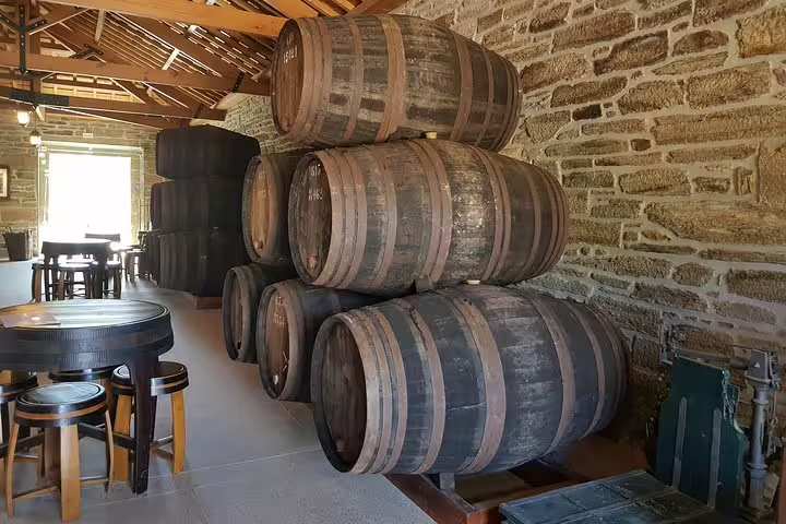 Rustic wine cellar in Douro Valley with stacked wooden barrels, showcasing traditional wine aging techniques.