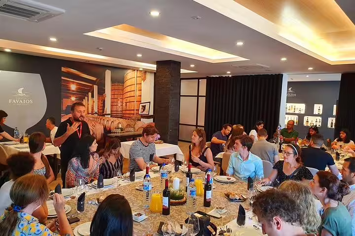 Group enjoying a wine tasting lunch at a Douro Valley winery, featuring elegant decor and attentive service.