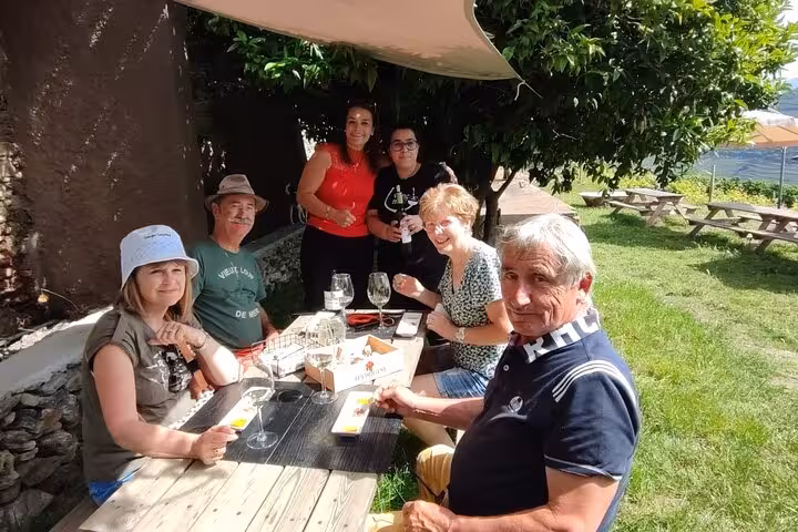 Guests enjoy a Douro Valley wine tasting lunch outdoors near Pinhão vineyards on the Visit Pinhão tour