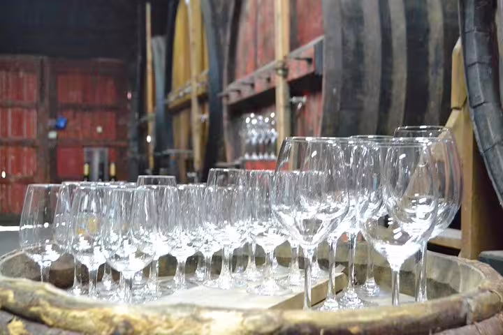 Wine tasting setup with empty glasses on a barrel in a Douro Valley vineyard tour cellar.