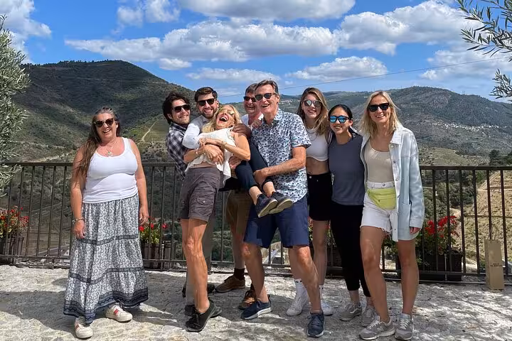Happy group at Douro Valley scenic viewpoint on expert-guided wine tour with boat cruise, lunch and tastings
