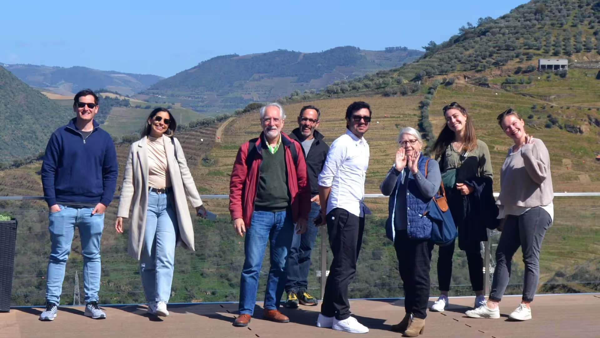 Image of a guest group during a winery visit with a Douro Valley view behind them on Cooltour Oporto's Douro Valley Wine Tour from Porto