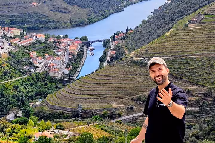 Guide overlooking Douro River and terraced vineyards on private wine tour with 1h cruise and lunch from Porto
