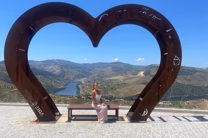 Scenic Douro Valley viewpoint near Pinhão with heart sculpture and river terraces on a Porto wine tour with sommelier.
