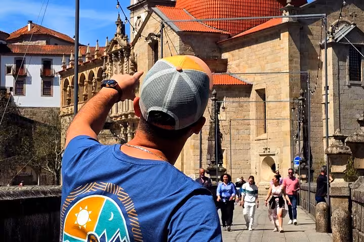 Tour guide pointing out historic Porto landmark during private Douro Valley wine tour day trip from Porto