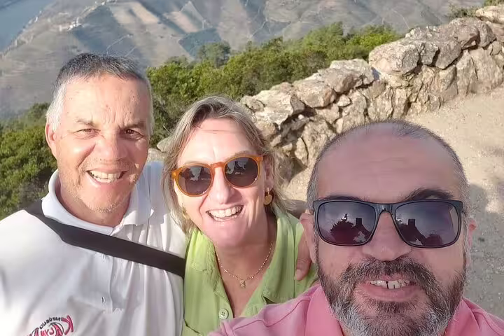 Tourists enjoying breathtaking views of Douro Valley during a private luxury wine tour.