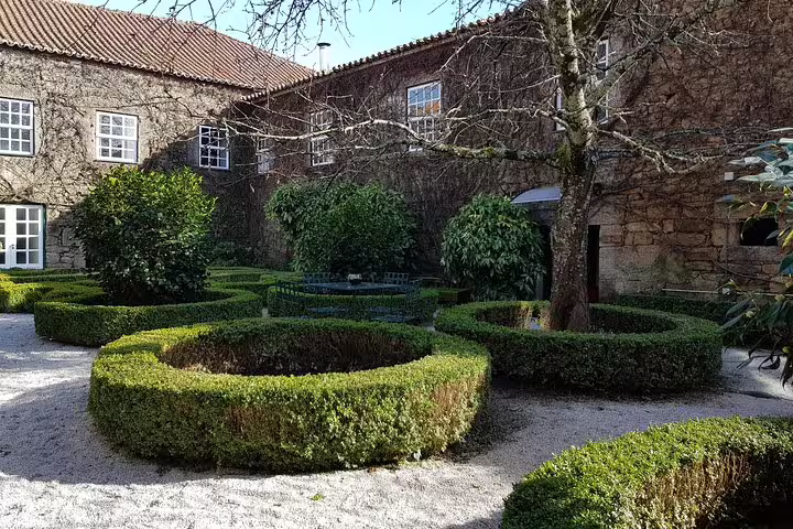 Charming courtyard garden of a Douro Valley winery with manicured hedges, offering a serene setting for a wine tour.