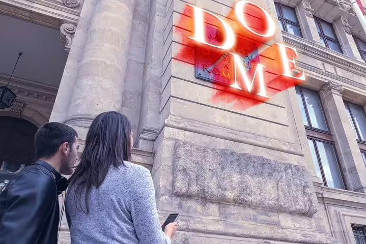 Two tourists looking up at a glowing DOME sign on a historic Bucharest building facade